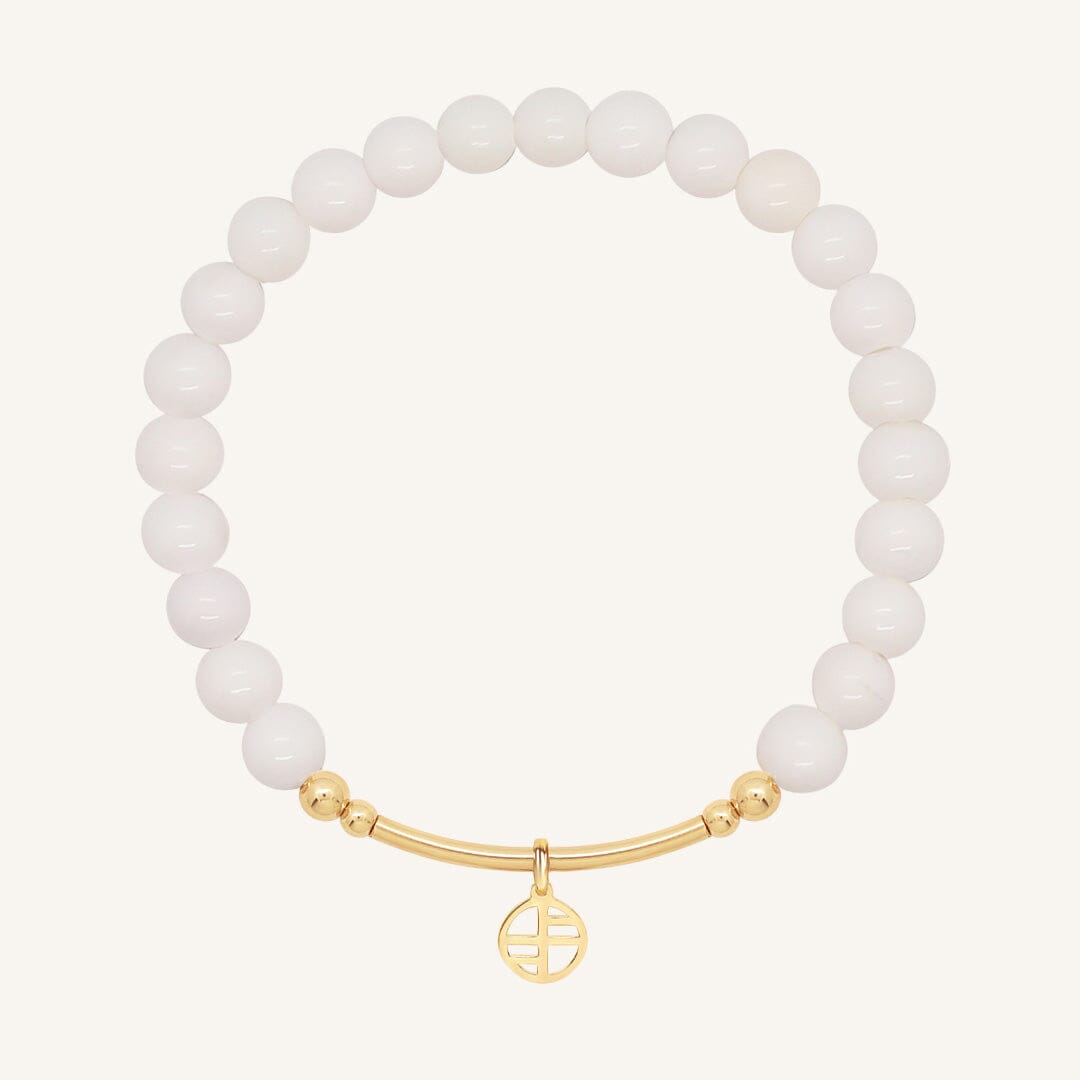 White beaded bracelet with a gold clasp on a white background