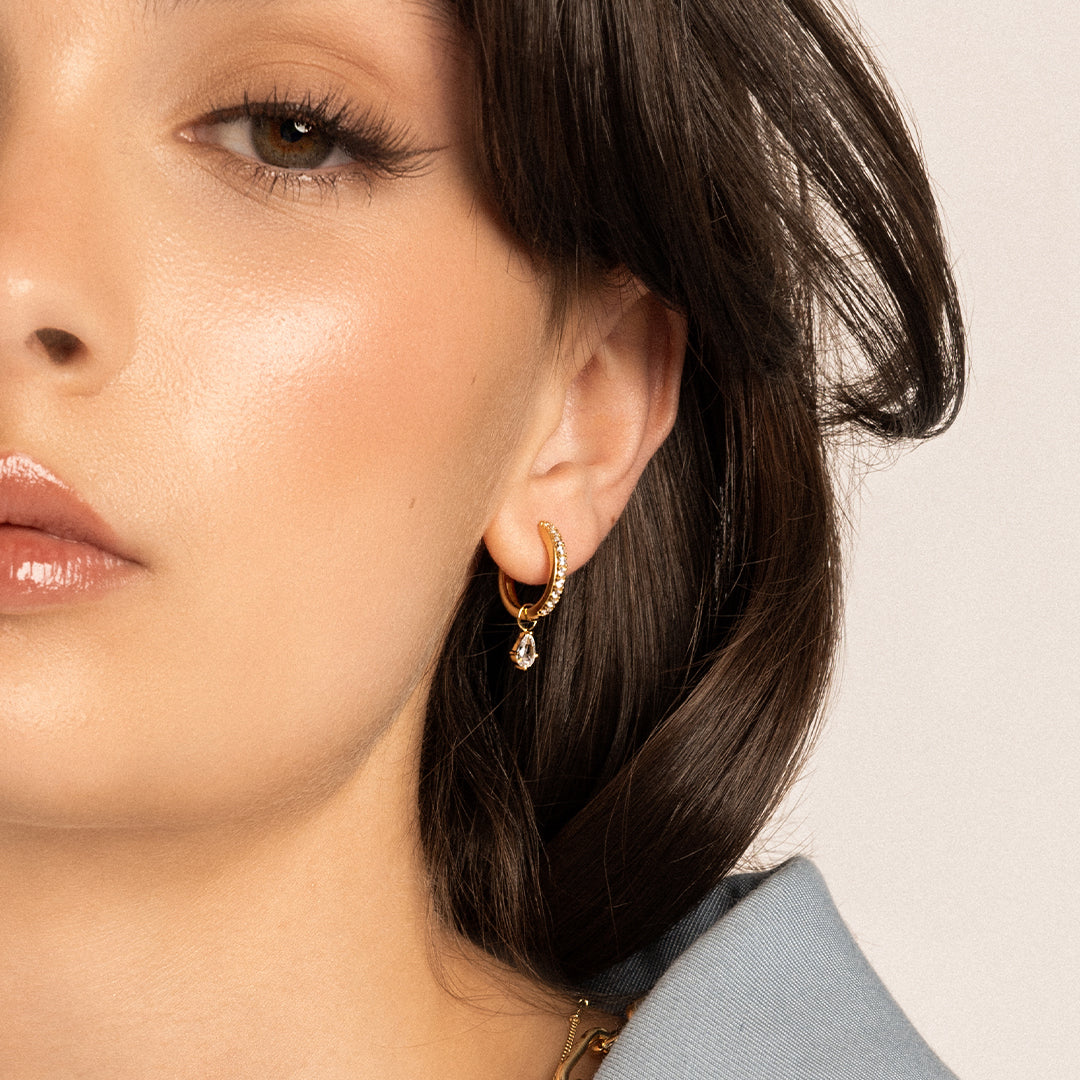 Small gold hoops, with cubic zirconias wrapped around, with hoop charm, in models ear