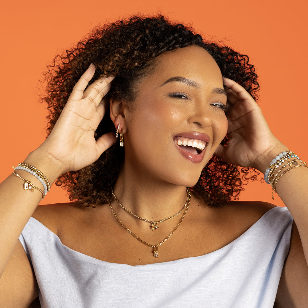 A pair of hoop earrings with transparent crystal embellishments, worn by model