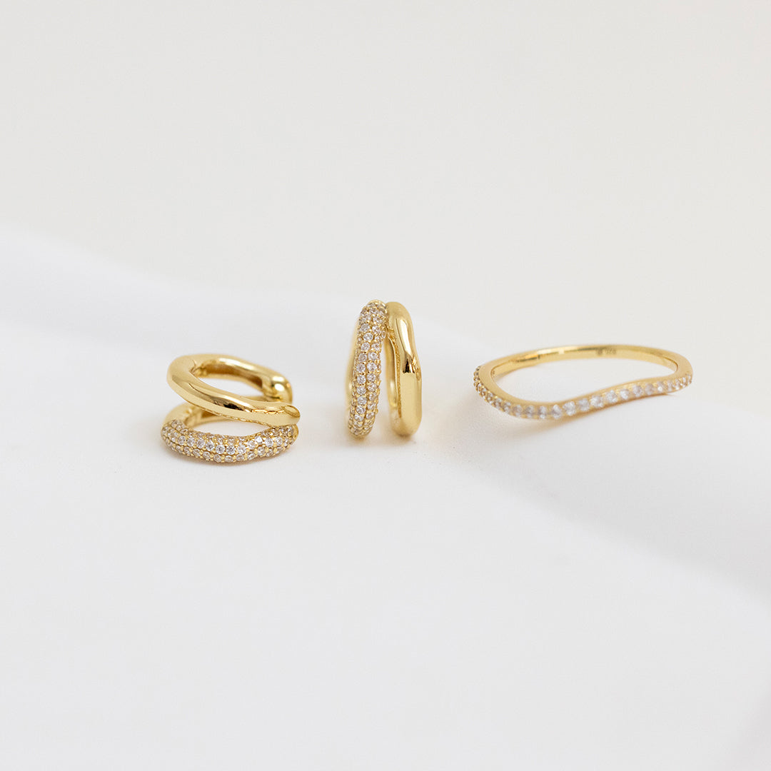 close up shot of gold double huggies with cubic zirconias with matching ring