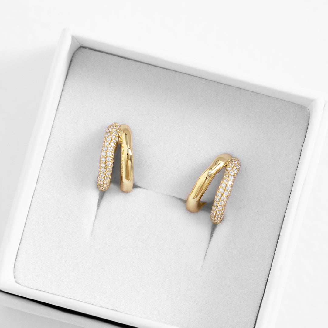 close up shot of gold double huggies with cubic zirconias in white box