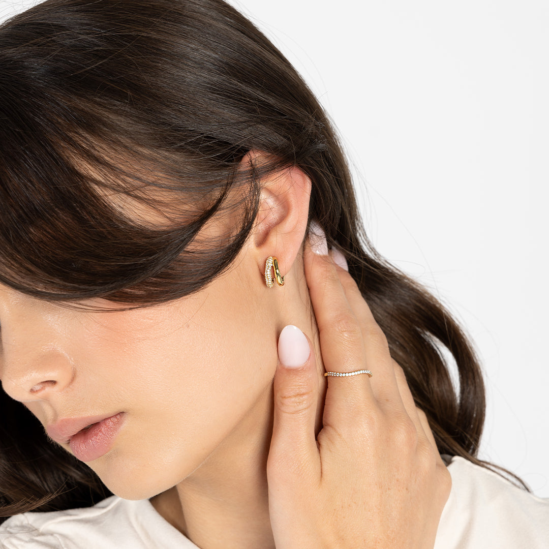 A slim, elegant ring with multiple small cubic zirconias set in a coloured band. Worn on finger.