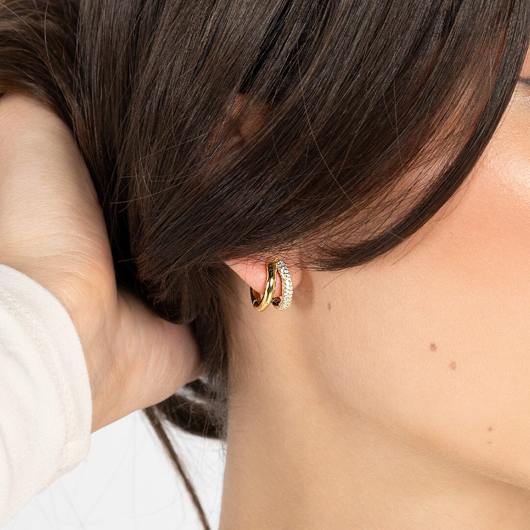 close up shot of gold double huggies with cubic zirconias in ear