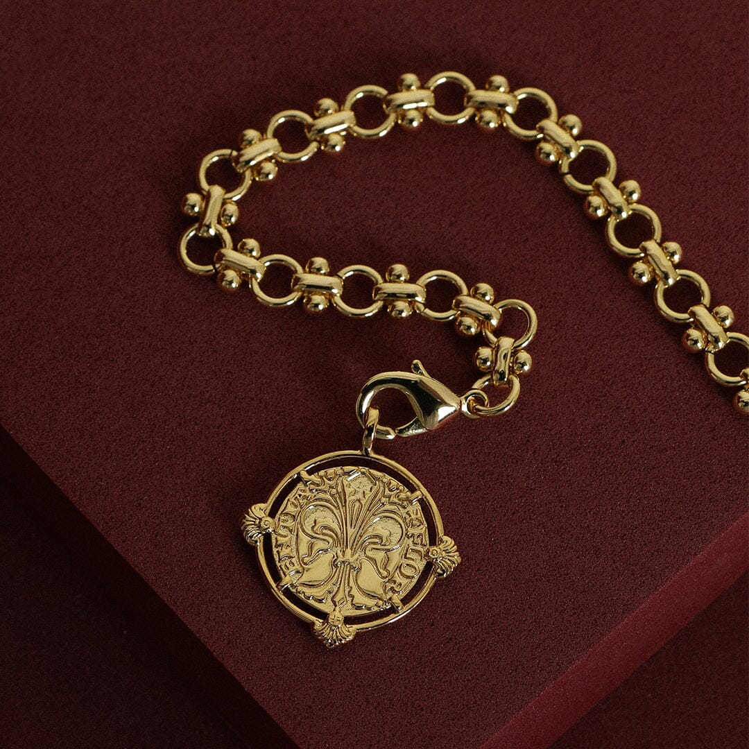 gold chain necklace inspired by Eiffel tower architecture with gold pendant featuring intricate patterns inspired by Palace of Versailles on a red background