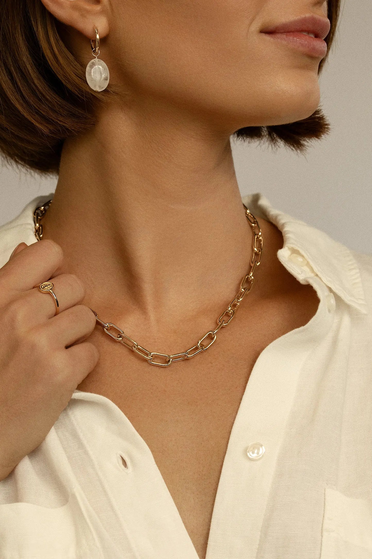 A chunky link chain necklace in gold tone worn on models neck