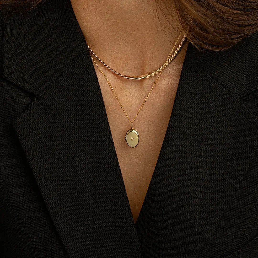 Gold oval locket on chain, worn around neck