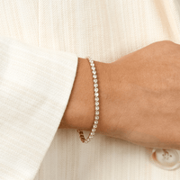 A silver-coloured tennis bracelet with clear cubic zirconias linked together, featuring a extender chain for adjustable length.