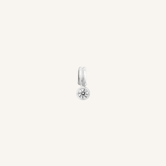 Round silver charm with bezel-set white cubic zirconia representing the April birthstone