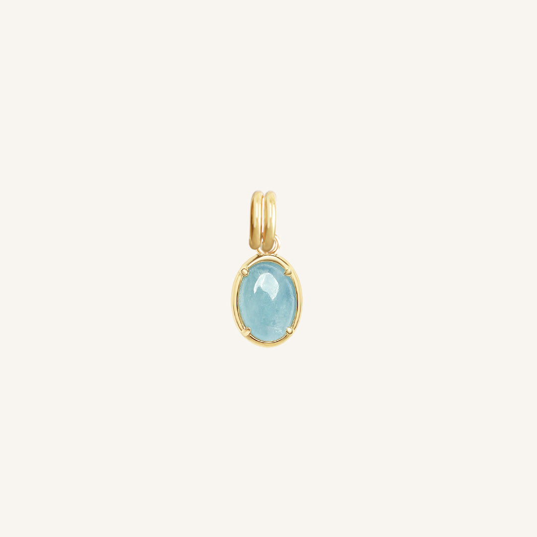 Gold pendant with a blue stone on a white background