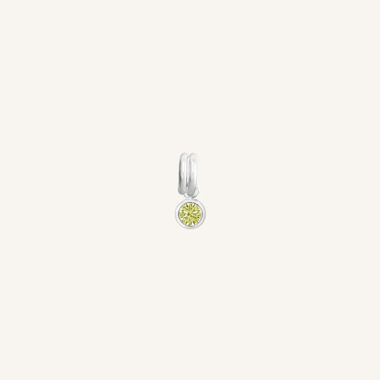 Silver round charm with bezel-set peridot green cubic zirconia representing the August birthstone