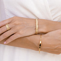 Gold ring with textured design on a white background
