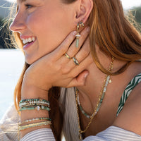 Gold ring with a green gemstone on a light gray background