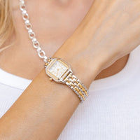 A silver-toned Louis Watch with a link bracelet and a square face featuring Roman numerals.