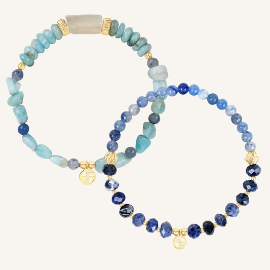 Two beaded bracelets with blue and gold accents on a white background
