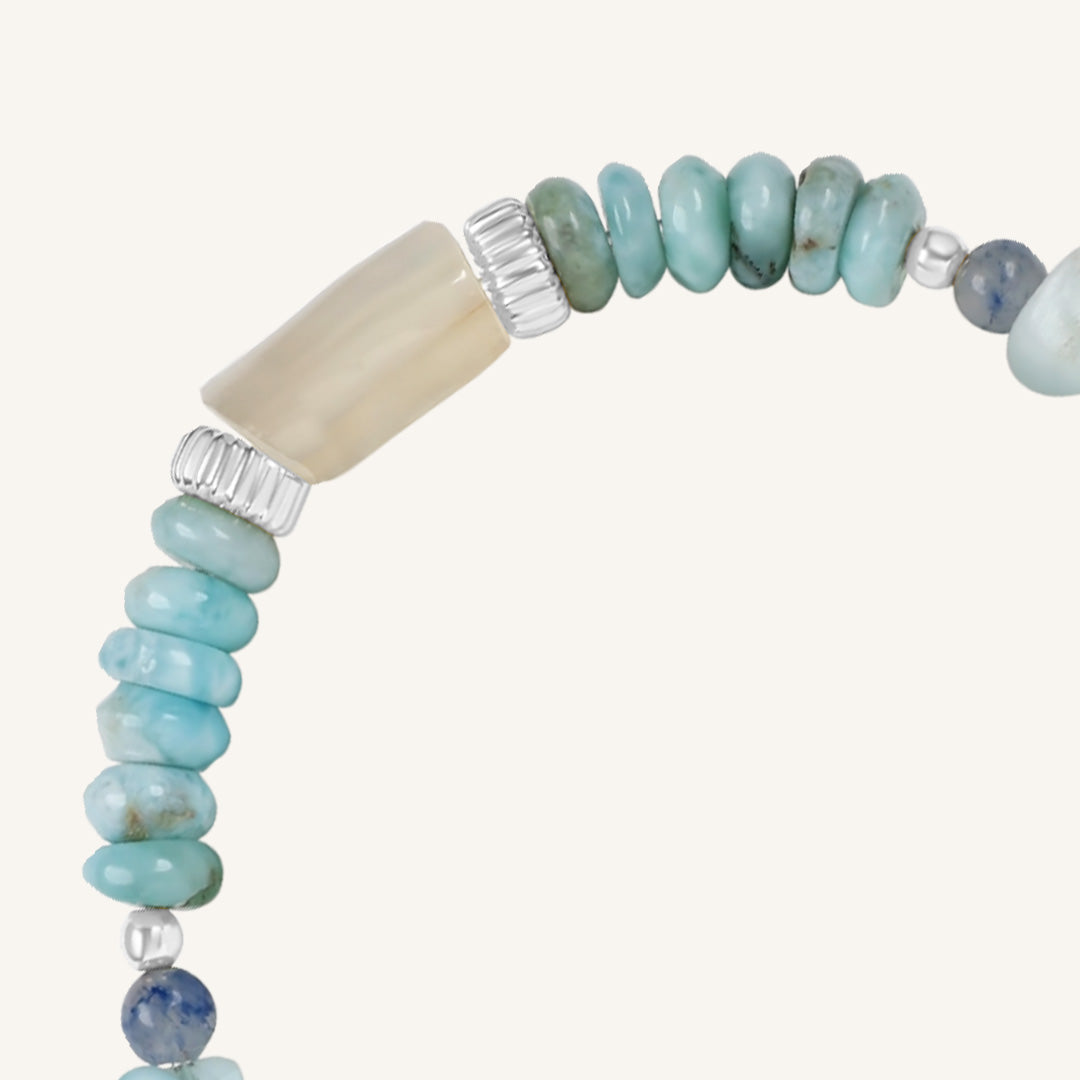 Beaded bracelet with turquoise and beige beads on a white background