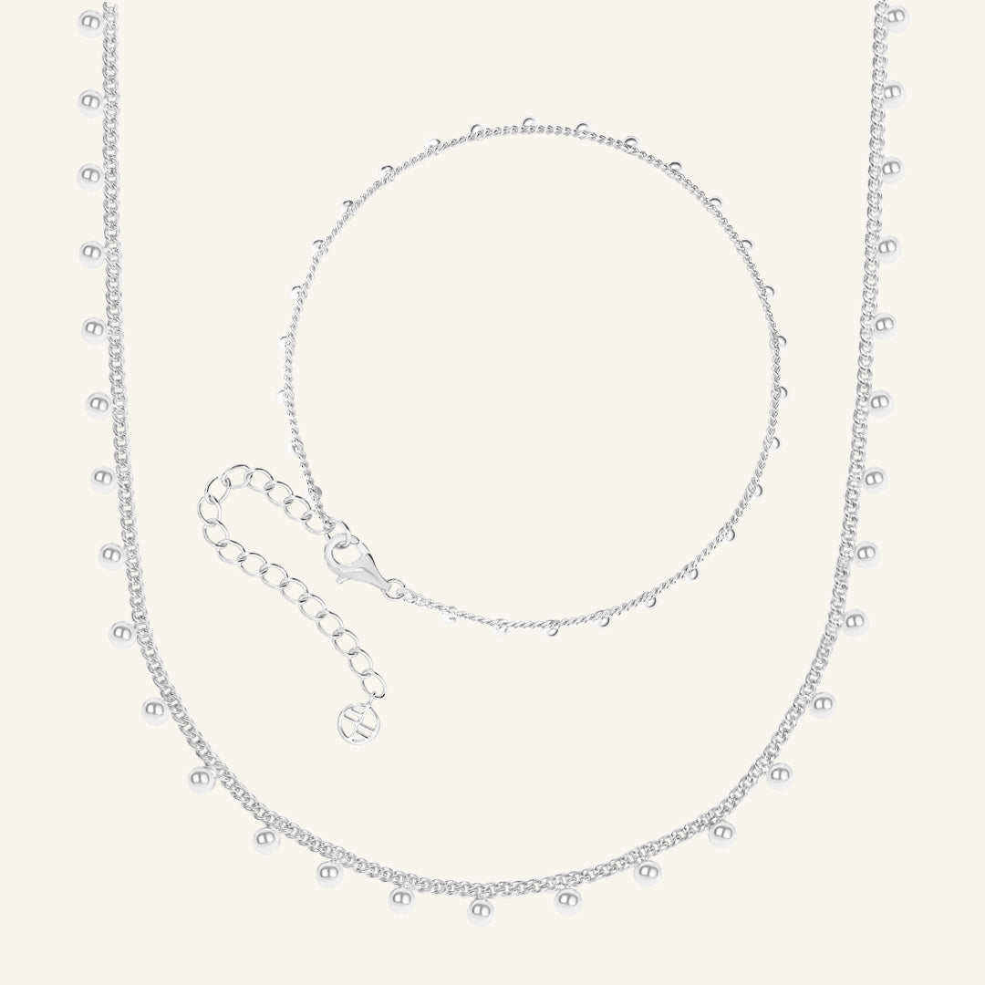 Silver necklace with small beads on a white background