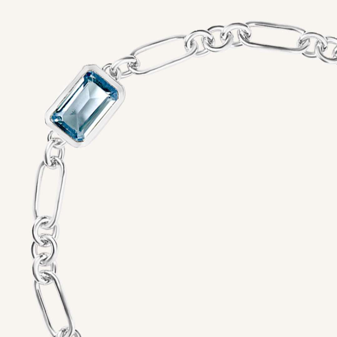 Silver bracelet with a blue gemstone on a white background