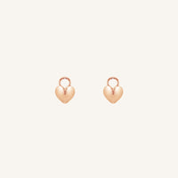 A pair of heart-shaped rose hoop charms against a white background