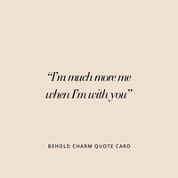 A pair of gold hoop earrings with cubic zirconias with heart charms attached to them, displayed against a white background.