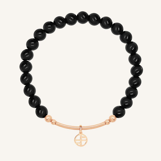 Black beaded bracelet with a rose gold bar on a white background