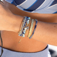 Two beaded bracelets with blue and gold accents on a white background