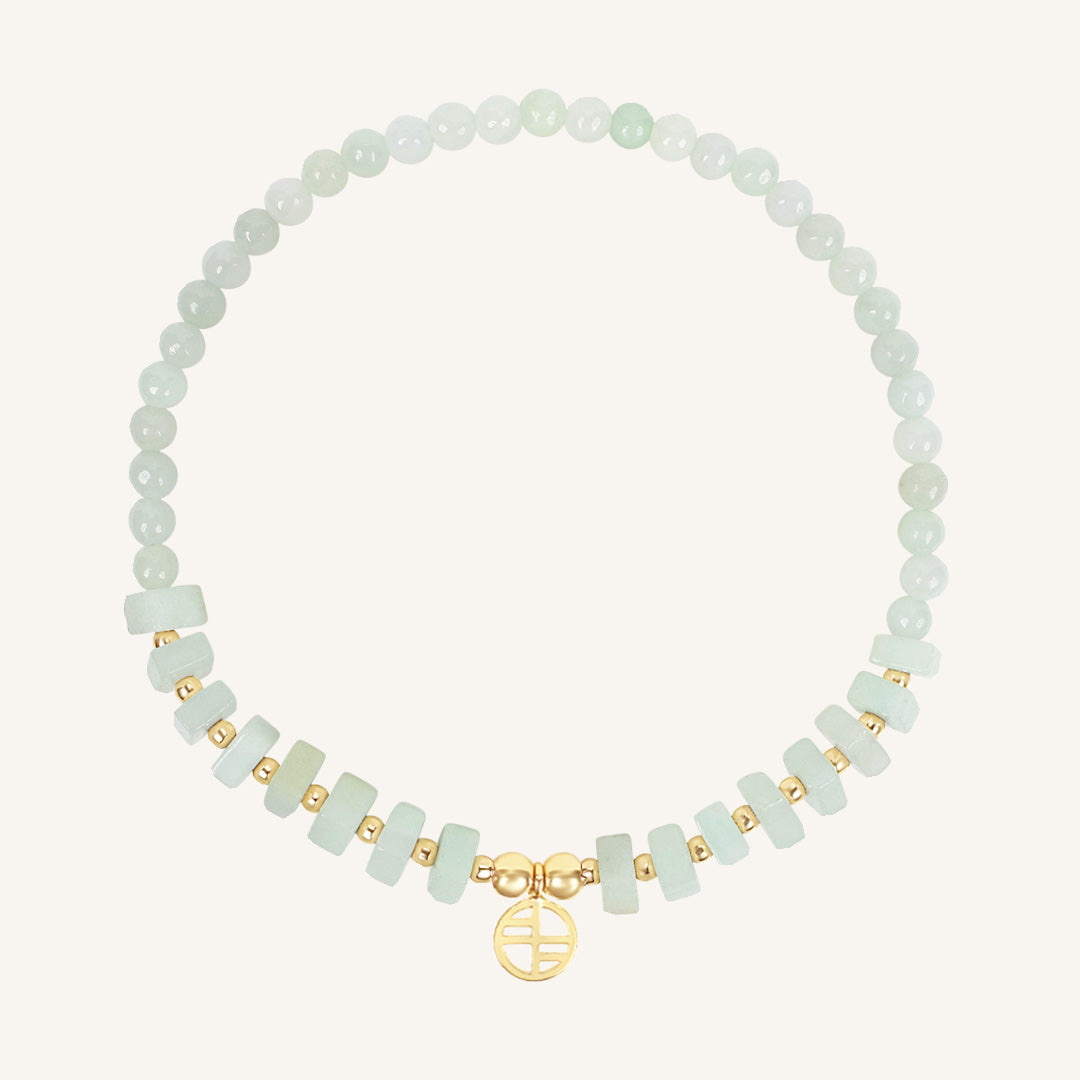 Bracelet with light green beads and gold accents on a white background
