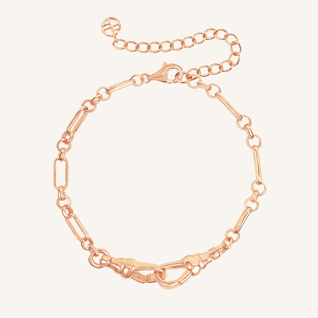 Rose gold chain bracelet on a light pink background