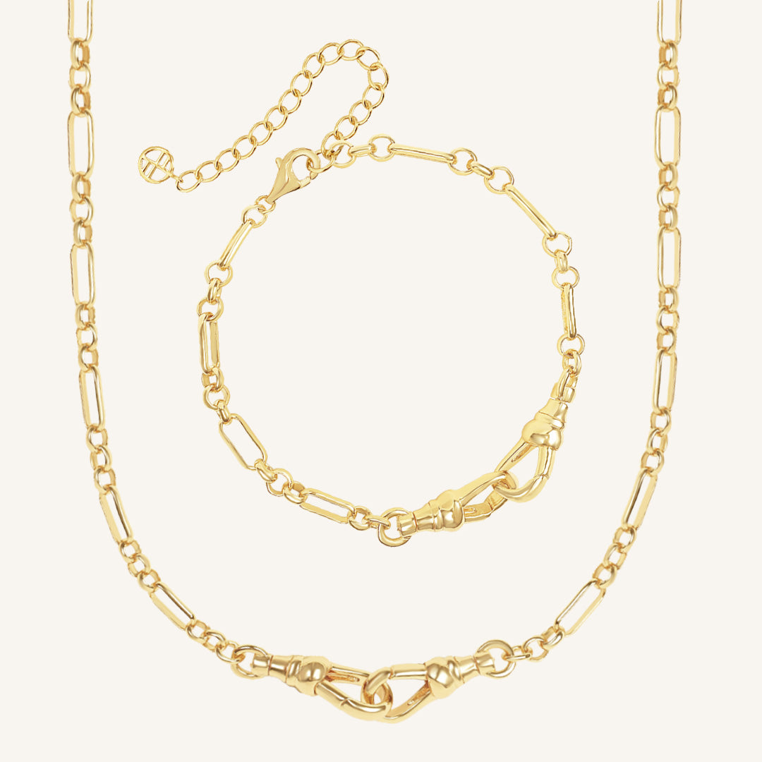 Gold chain necklace and bracelet on a light beige background