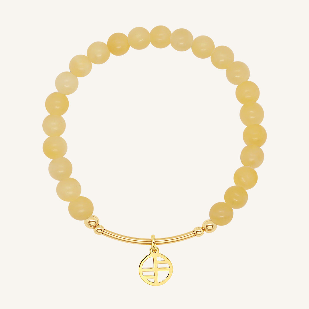 A yellow jade bracelet with a gold charm, beaded design, and gold-tone metal tone.