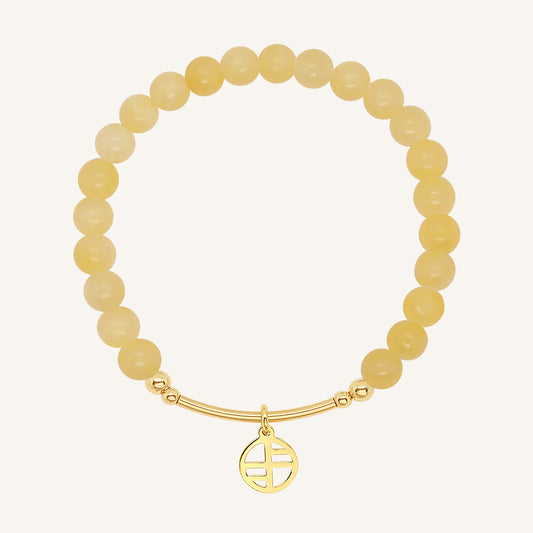 A yellow jade bracelet with a gold charm, beaded design, and gold-tone metal tone.