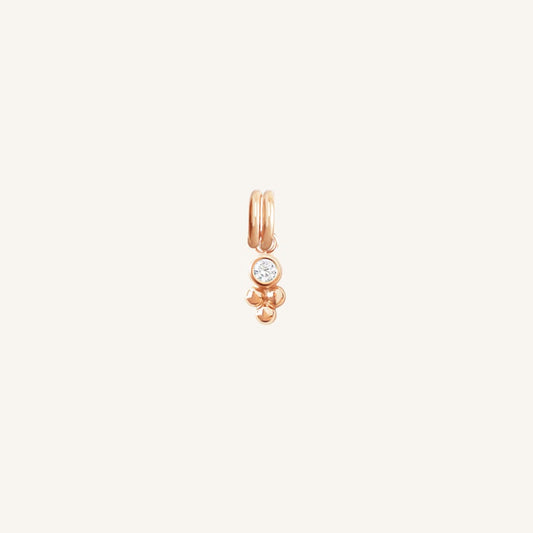 A small rose charm featuring a cubic zirconia and a floral design.