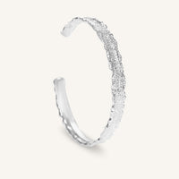 Silver bracelet with textured design on a white background