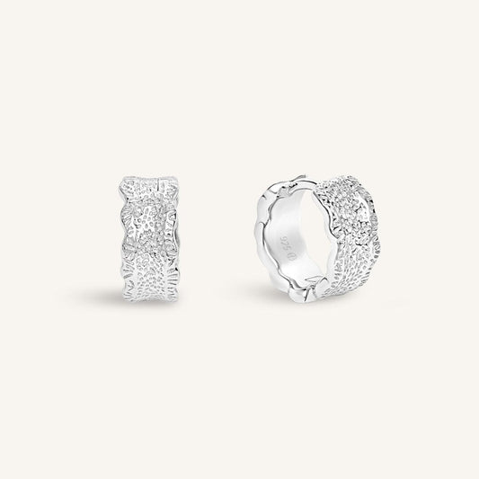Silver hoop earrings on a light gray background
