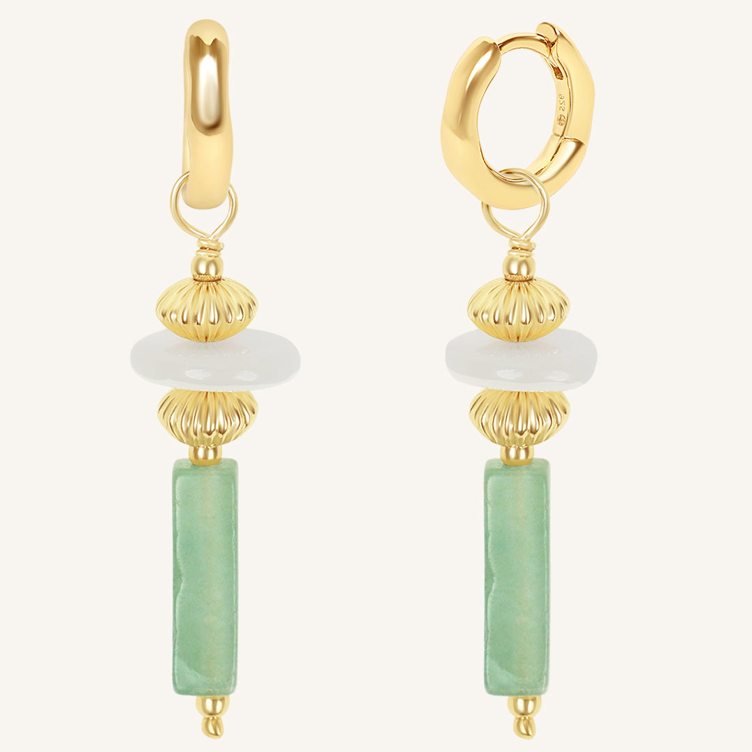 Gold hoop earrings with green and white bead drops on a white background