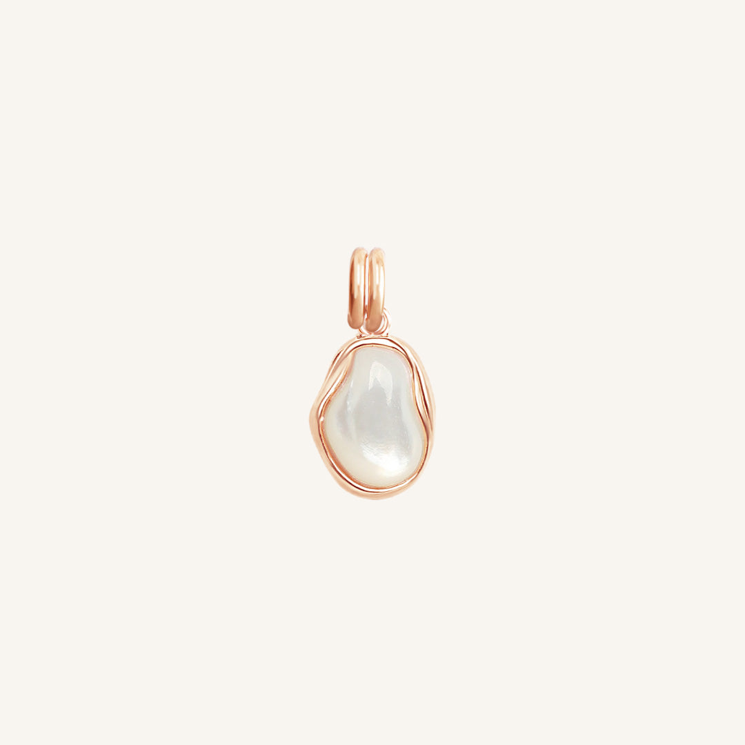 Rose gold pendant with a white stone on a light beige background