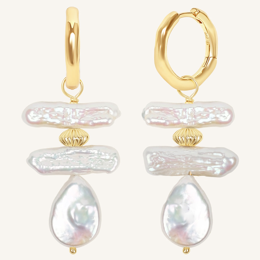 Gold hoop earrings with layered pearl drops on a white background