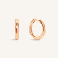 Rose gold hoop earrings on a light beige background