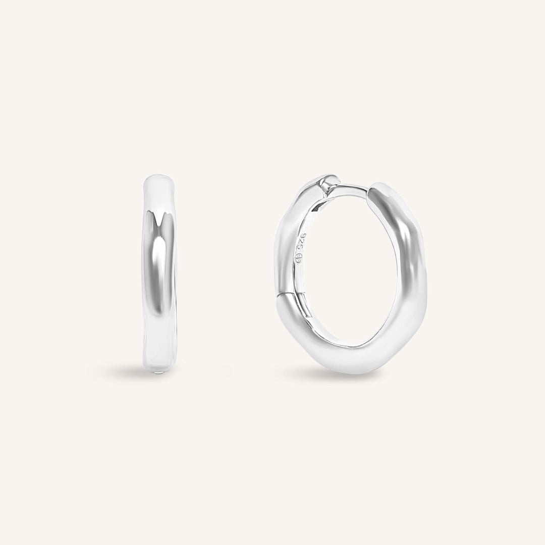 Silver hoop earrings on a light gray background