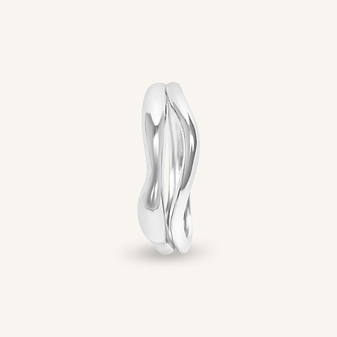 Silver ring with a wavy design on a light gray background