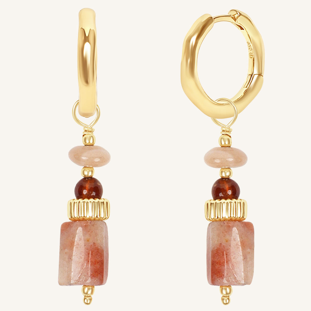Gold hoop earrings with stone beads on a white background