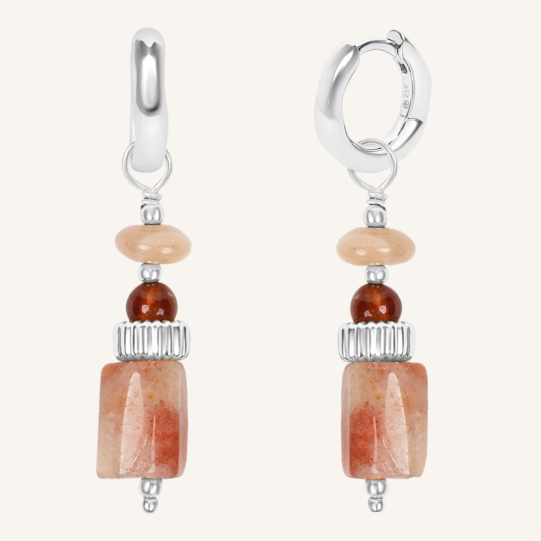 Pair of earrings with stone beads on a white background
