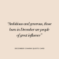 A gold birthstone charm with a blue cubic zirconia representing the month of December.