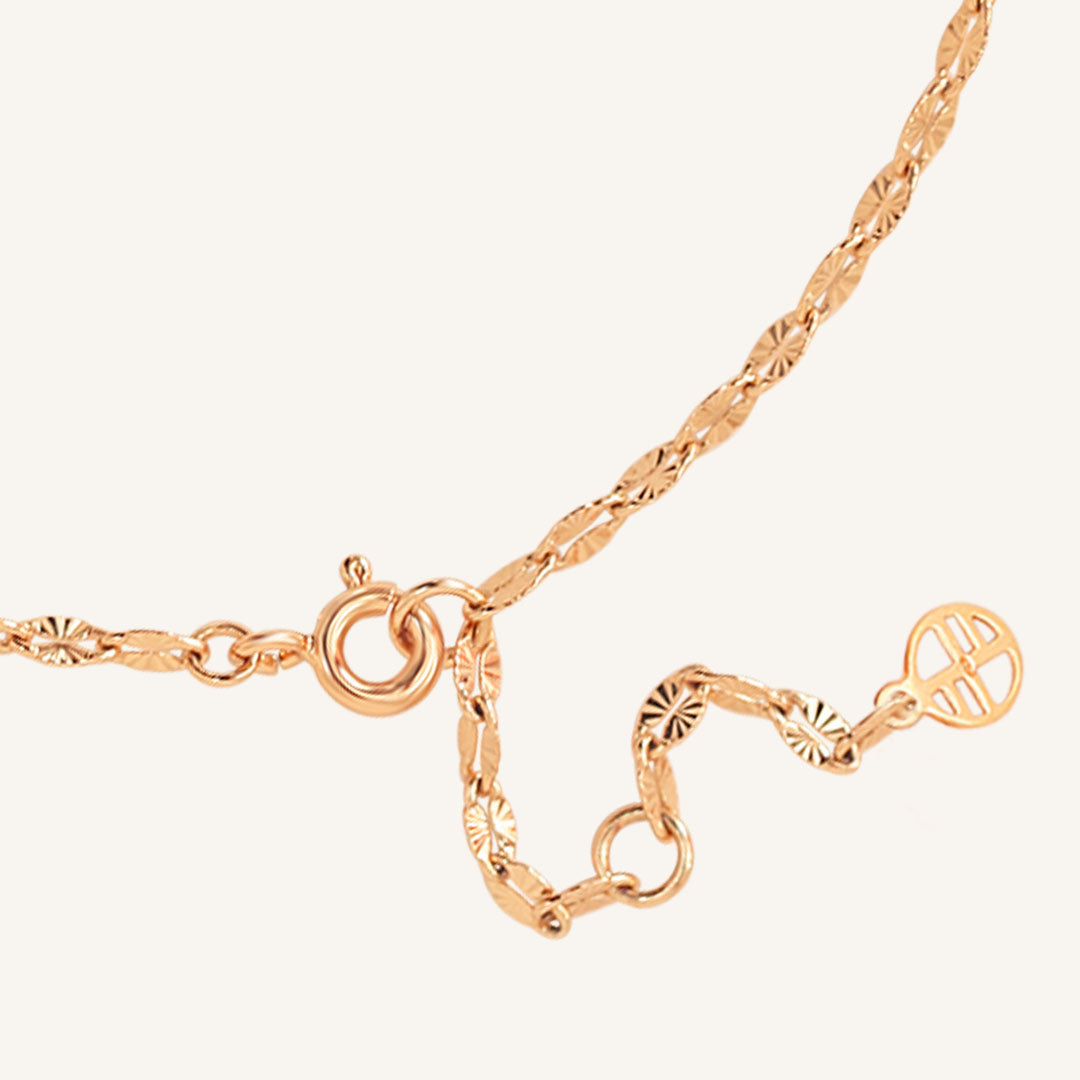 Rose gold necklace with intricate design on a white background