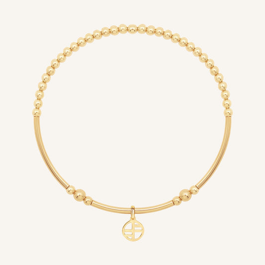 Gold bracelet with a small round charm on a white background