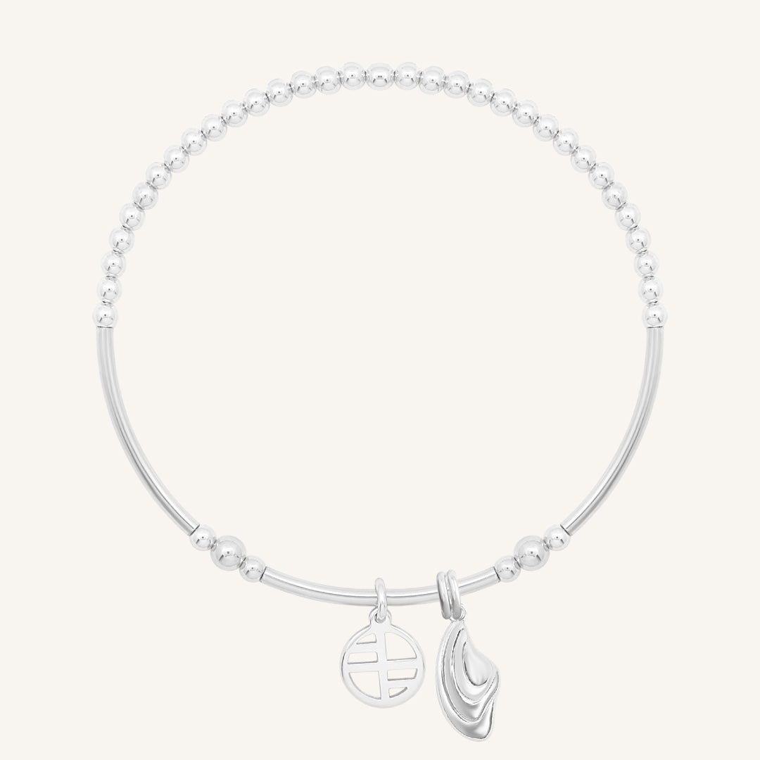 Silver bracelet with a leaf charm on a white background