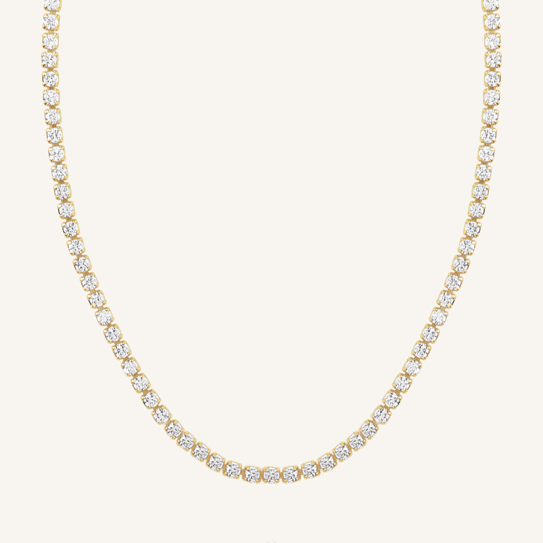 A tennis chain necklace with gold metal tone.