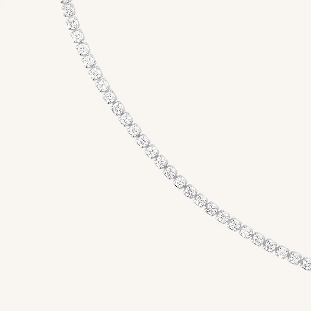 Close up of tennis chain necklace with silver metal tone.
