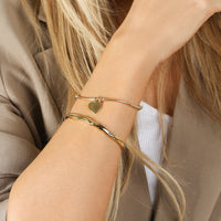 A rose bracelet with a beaded design and a heart-shaped charm, engraved with initials and a date 