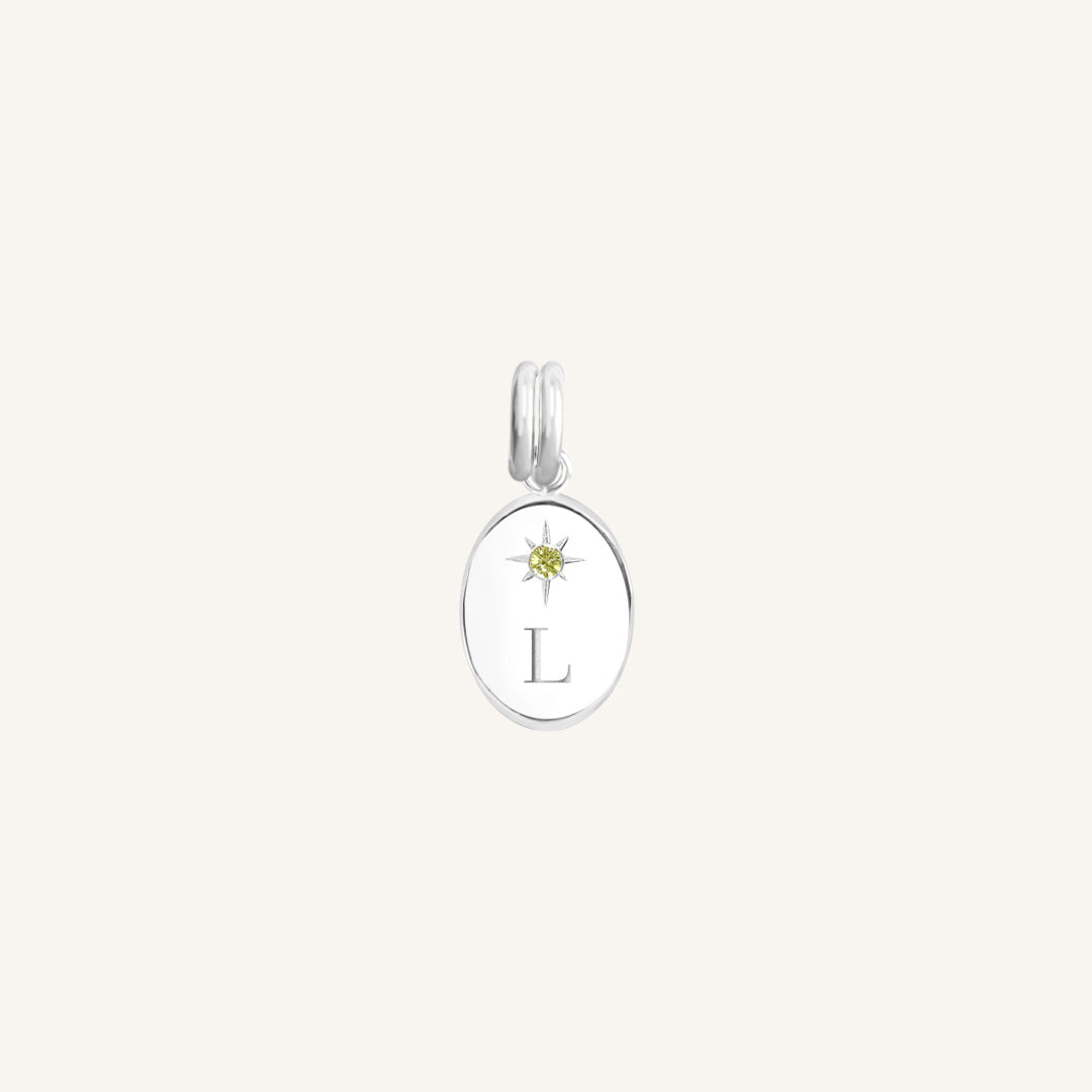Silver pendant with a yellow gemstone and letter 'L' on a white background