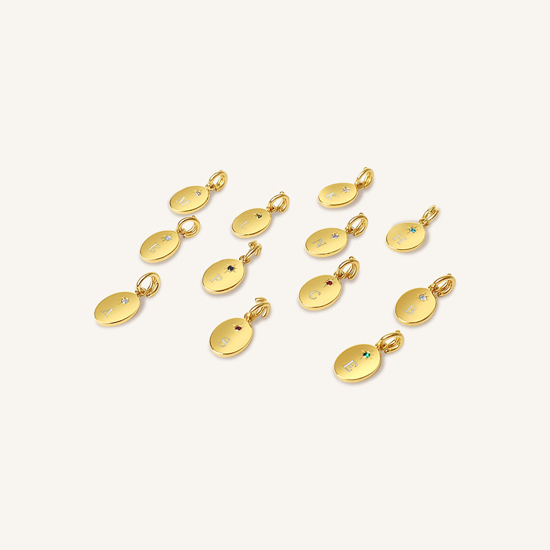 Gold pendants with embedded stones on a white background